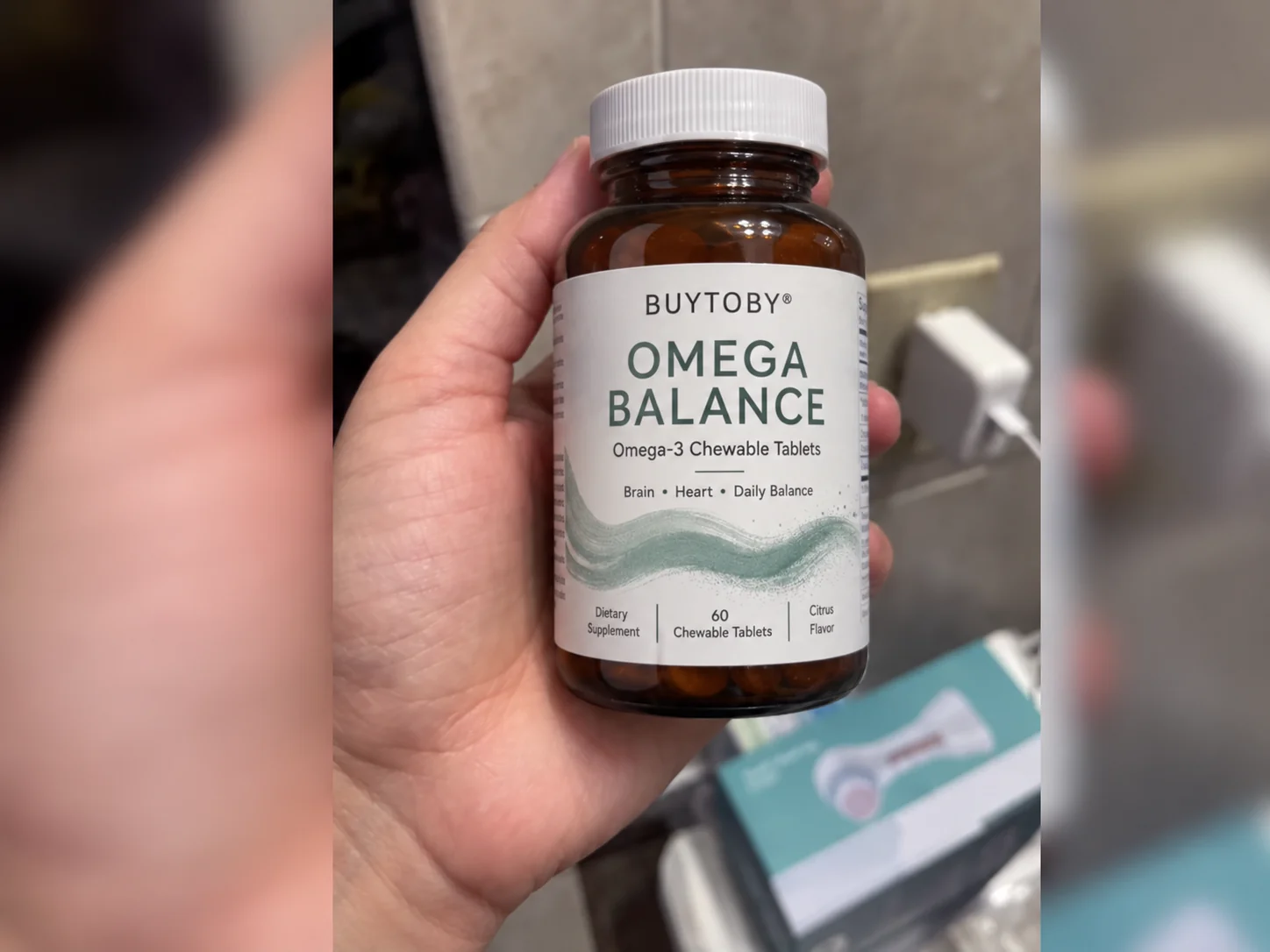 BuyToBy Omega Balance bottle held in one hand