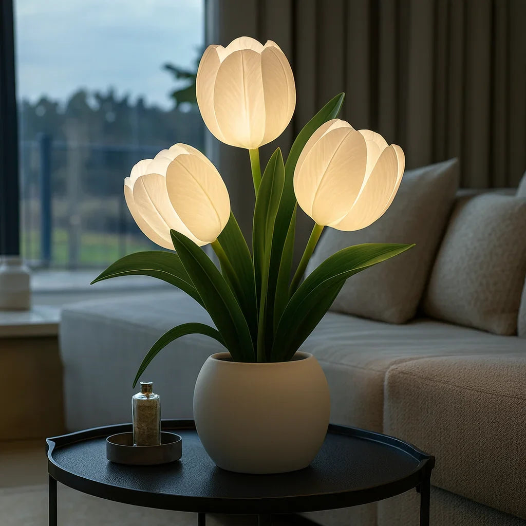 Lumiere Blossom LED decorative lamp featuring three glowing white tulip lights in a white pot, placed on a dark round side table in a modern living room setting.